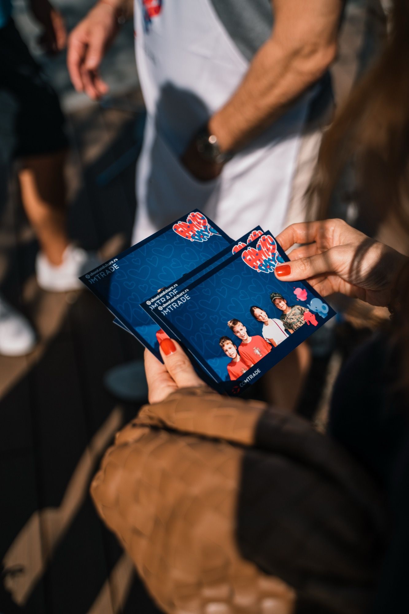 Odštampane fotografije sa personalizovanim okvirom u rukama gošće